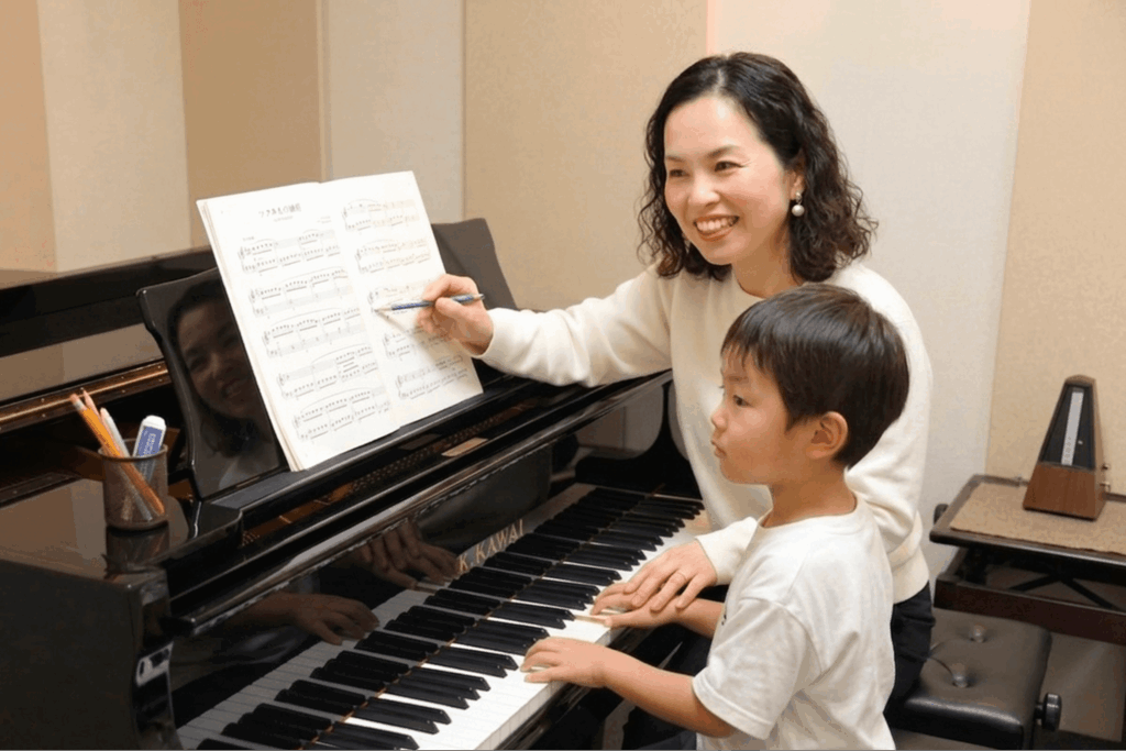 男の子へピアノレッスンをする講師