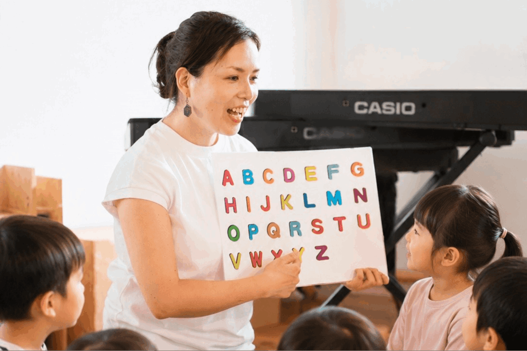英語リトミックをする講師とそれを囲む子どもたち